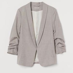 Woven fabric with a shawl collar, side-seam pockets, and 3/4-length sleeves.